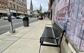 A new park bench and concrete garbage can on West Main Street