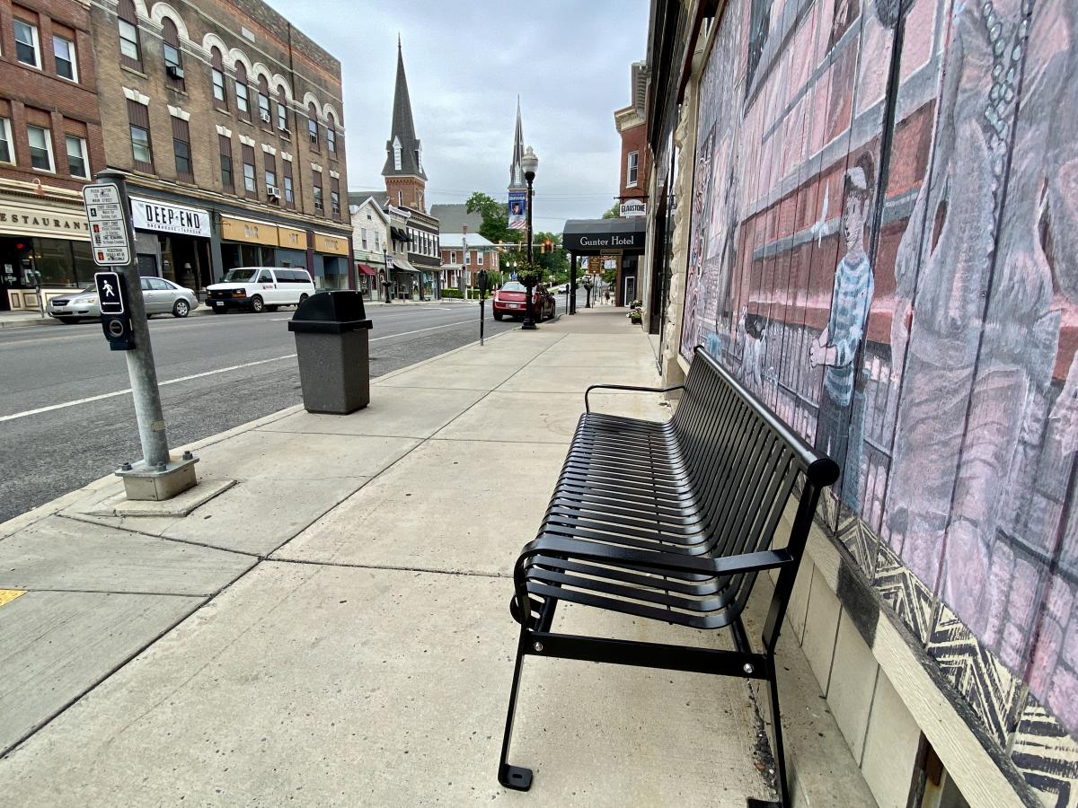 A new park bench and concrete garbage can on West Main Street