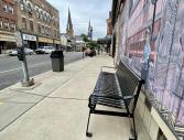 A new park bench and concrete garbage can on West Main Street